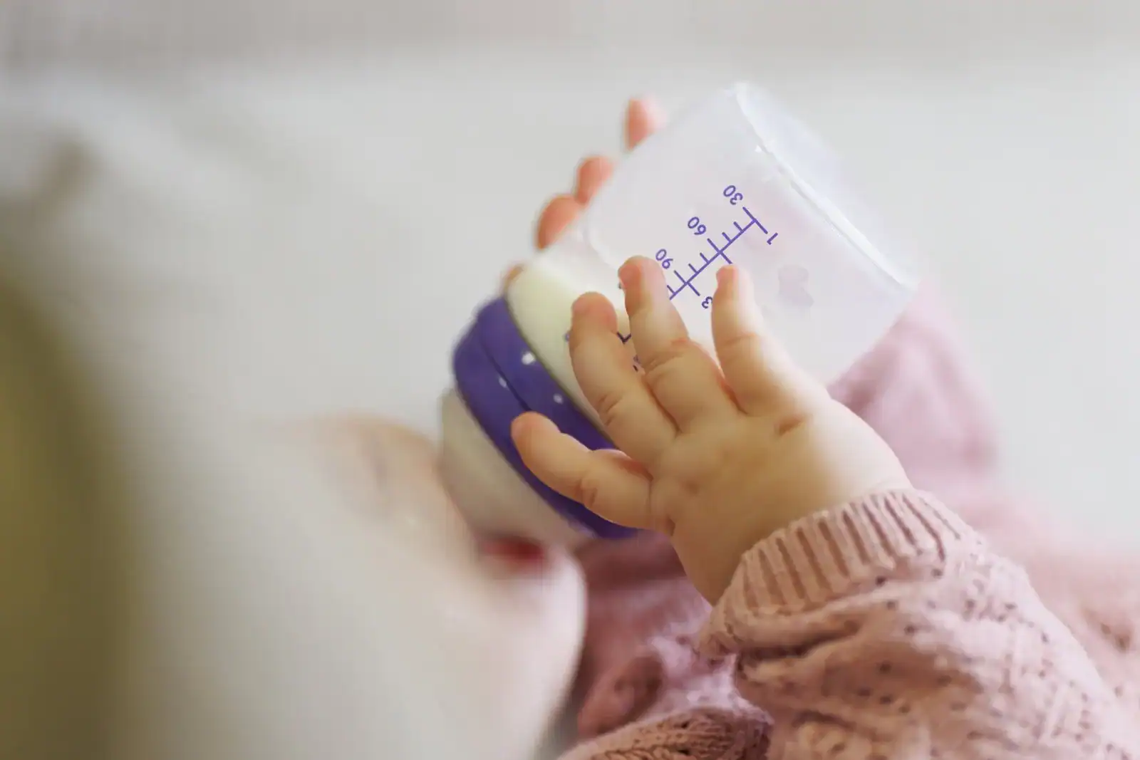 Anyatejes táplálás cumisüvegből Kisbaba a kezében tartja a cumisüveget